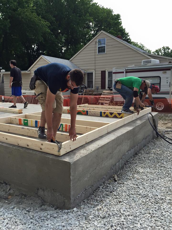 Men laying frame on concrete foundation